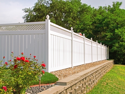 tall white vinyl fence with landscaping in the foreground